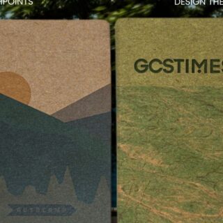 Two tall textured posters outdoors beside a tree and water: left shows a desert-malette mountain design, right a map-like green panel with 'GCSTIMES' text.