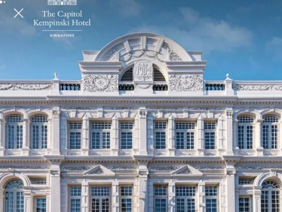 Facade of The Capitol Kempinski Hotel Singapore in white, with ornate neoclassical detailing and a clear blue sky; Shiji and hotel logos appear in the top left.