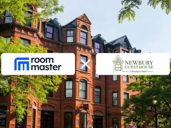 Red brick building with green trees and a banner showing the Room Master logo crossed with the Newbury Guest House logo.