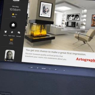 Smart display on a speaker base showing a modern living room with a fireplace and art, advertising Artography.