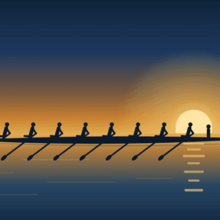 Silhouetted rowing team in a long boat gliding on calm water at sunset with a large sun on the horizon