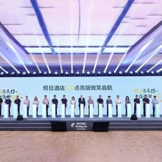 Row of people standing behind white podiums on a large stage at a conference, with a blue-lit ceiling and Chinese text on the backdrop.