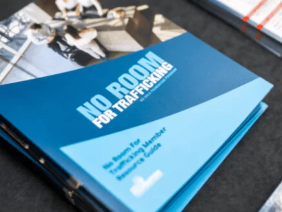 Blue pamphlet on a table with the bold title 'NO ROOM FOR TRAFFICKING', indicating an anti-trafficking awareness brochure.