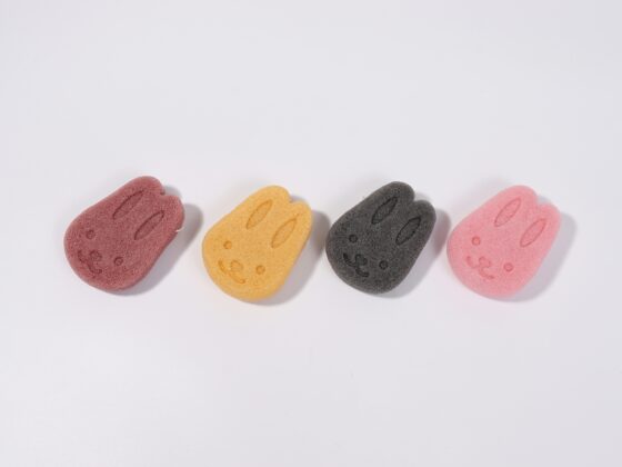 Five colorful gummy bear–shaped erasers with smiling faces lined along the bottom on a white background (red, yellow, gray, and pink).