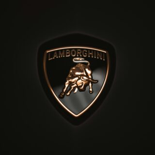 Close-up of the Lamborghini shield logo with a gold bull on a dark background.