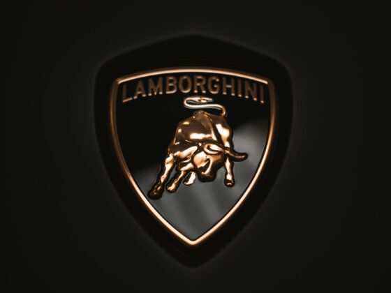 Close-up of the Lamborghini shield logo with a gold bull on a dark background.