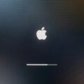 Dark screen with a glowing white Apple logo and a thin progress bar near the bottom, suggesting macOS startup or update progress.