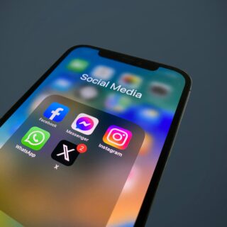 Close-up of a smartphone screen displaying social media apps including Facebook, Messenger, Instagram and WhatsApp.