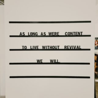 White vertical panel with black tape bars obscuring lines of text; a partial quote is visible behind the bars.