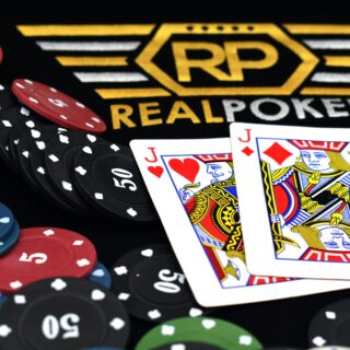 Poker chips in red, black, blue, and green surround two Jack cards on a dark table with a gold RP emblem.