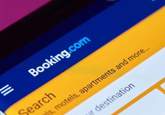 Booking.com mobile app screen with a blue header and an orange search area.