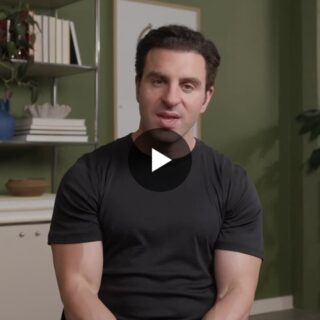 Video thumbnail: man in a black T-shirt sits in a green-walled room, speaking to the viewer with a play button overlay.