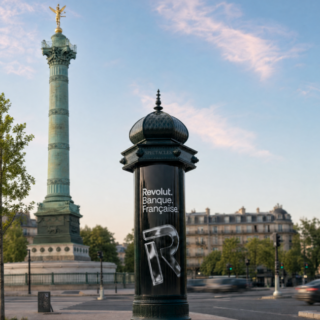 Paris street scene with the July Column monument and a black cylindrical ad column reading 'Revolut. Banque Française'. The sky is blue and light clouds above. (informative)