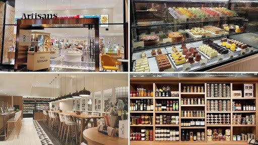 Storefront of a modern bakery café named Artisans, bright interior visible through the glass storefront.