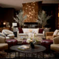 Luxurious hotel lobby lounge with beige chairs, burgundy ottomans, and a central round coffee table with a floral arrangement.