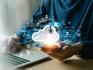 Person holding a glowing cloud icon above a laptop, illustrating cloud computing and data exchange.
