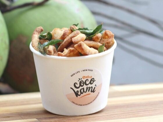 White cup of crispy fried snacks with green herbs, Coco Kami logo on the front.