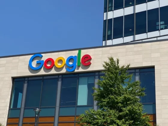 Google logo on the facade of a modern office building under a clear blue sky