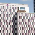 Facade of a multi-story Premier Inn hotel with pink and white window panels and a sign reading 'Premier Inn' at the top.