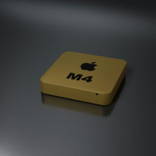 Yellow rectangular box with Apple logo and 'M4' printed on it, resting on a dark reflective surface.