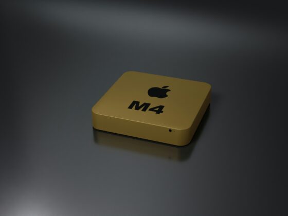 Yellow rectangular box with Apple logo and 'M4' printed on it, resting on a dark reflective surface.