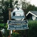 Outdoor wooden sign for Harbourview Coffeehouse in Tofino, advertising kayak tours, retail, clothing and books; 320 Main St.