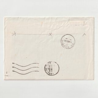 Close-up of a worn envelope edge with a circular postmark and partial postage stamp, showing creases and wear.