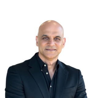 Professional headshot of a smiling, bald man in a black blazer against a white background.