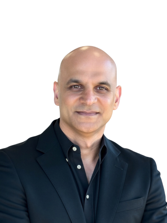 Professional headshot of a smiling, bald man in a black blazer against a white background.