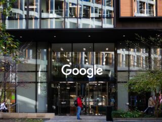 Exterior view of a Google office building with a large white 'Google' logo on glass facade and pedestrians nearby.
