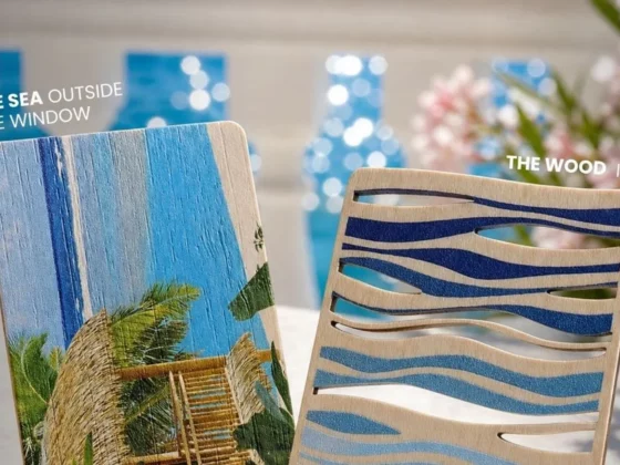 Two decorative wooden panels — left with a tropical beach scene, right with blue wave-cut patterns — blurred blue bottles and flowers in the background.