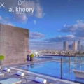 Rooftop swimming pool with loungers and a city skyline in the distance; Shiji x Al Khoory Hotels branding visible at the top left.