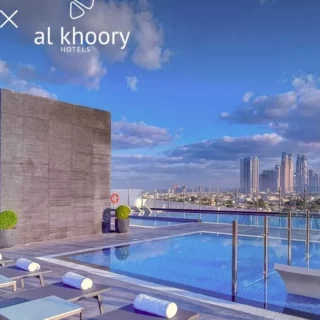 Rooftop swimming pool with loungers and a city skyline in the distance; Shiji x Al Khoory Hotels branding visible at the top left.
