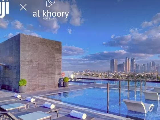 Rooftop swimming pool with loungers and a city skyline in the distance; Shiji x Al Khoory Hotels branding visible at the top left.