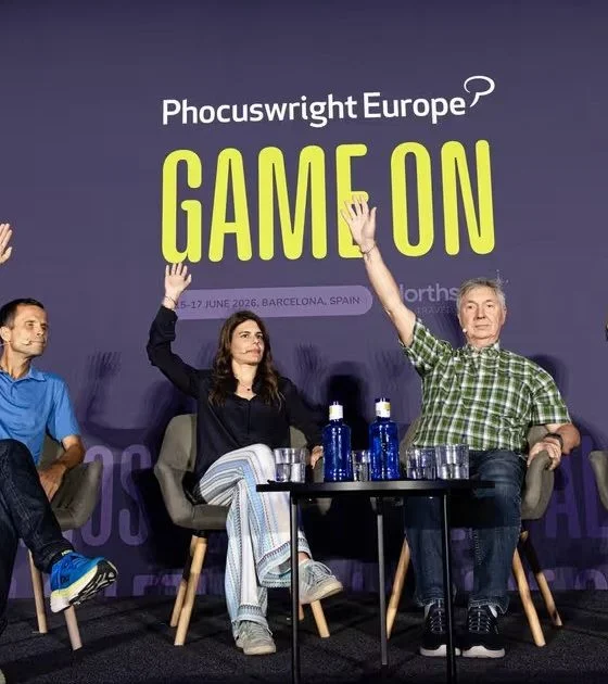 Panel of four speakers on a stage at Phocuswright Europe, waving their hands during a 'GAME ON' session on a purple backdrop.