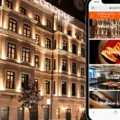 Night view of a warmly lit hotel facade with a smartphone beside it showing the Canopy by Hilton app menu.
