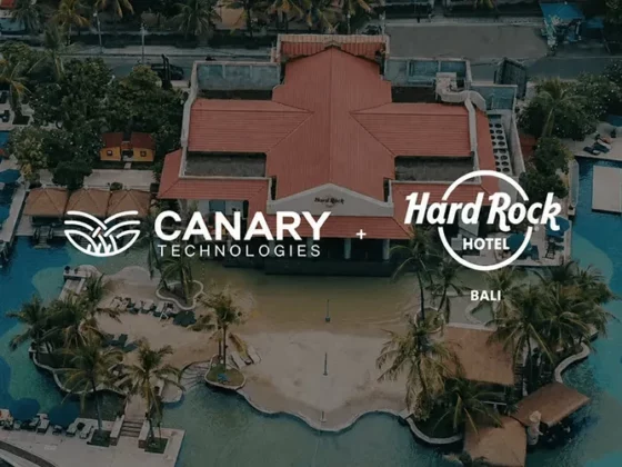Aerial view of a tropical resort with a red-roof building and blue pools, overlaid with Canary Technologies and Hard Rock Hotel Bali branding (partnership).