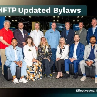Group of twelve professionals posing in a convention hall for the HFTP Updated Bylaws announcement.