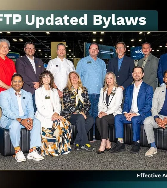 Group of twelve professionals posing in a convention hall for the HFTP Updated Bylaws announcement.