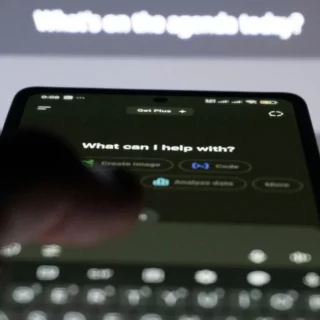 Phone screen shows a help prompt: 'What can I help with?'. The blurred background hints at a digital assistant UI outside the device screen.