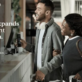 Cendyn logo with a man and woman at a service counter, travelers with luggage, conveying a payment-ecosystem promo.